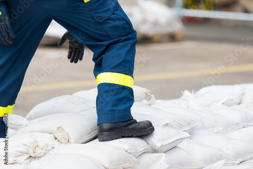 Helfer transportiert Sandsäcke