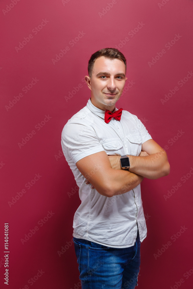 Portrait of smiling young man in red bow-tie and white t-shirt looking at camera.Studio shot Portrait of smiling young man in red bow-tie and white t-shirt looking at camera.Studio shot