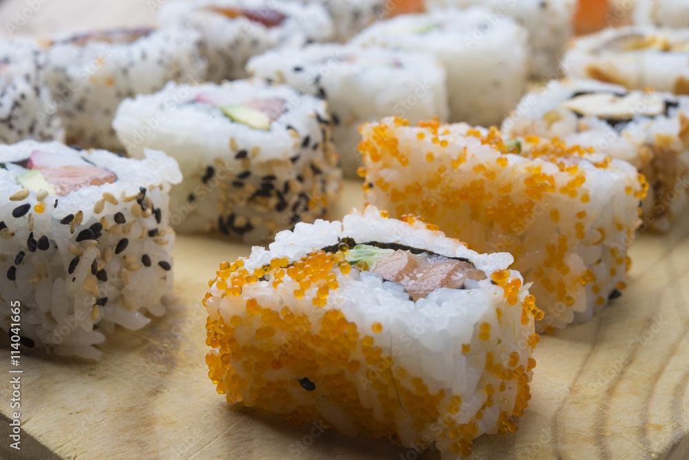 Different Sushi rolls,wasabi and ginger on a plate on wooden bac Different Sushi rolls,wasabi and ginger on a plate on wooden bac