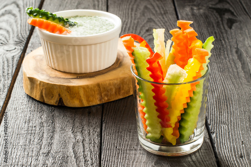 Slices of raw vegetables in glasses and yogurt sauce