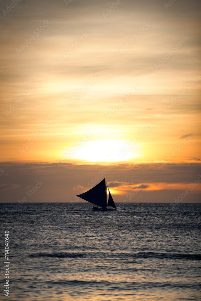 gold sunset with a sailboat