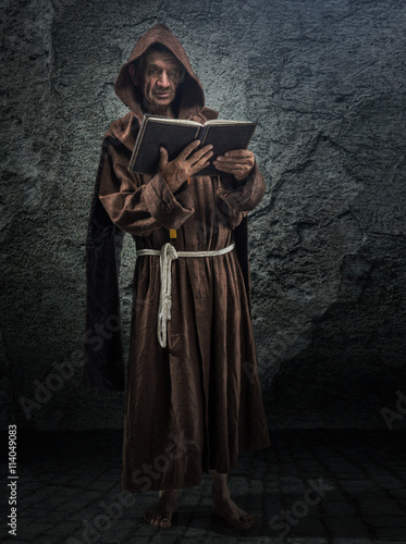 Senior monk, priest holds in his hand the Bible