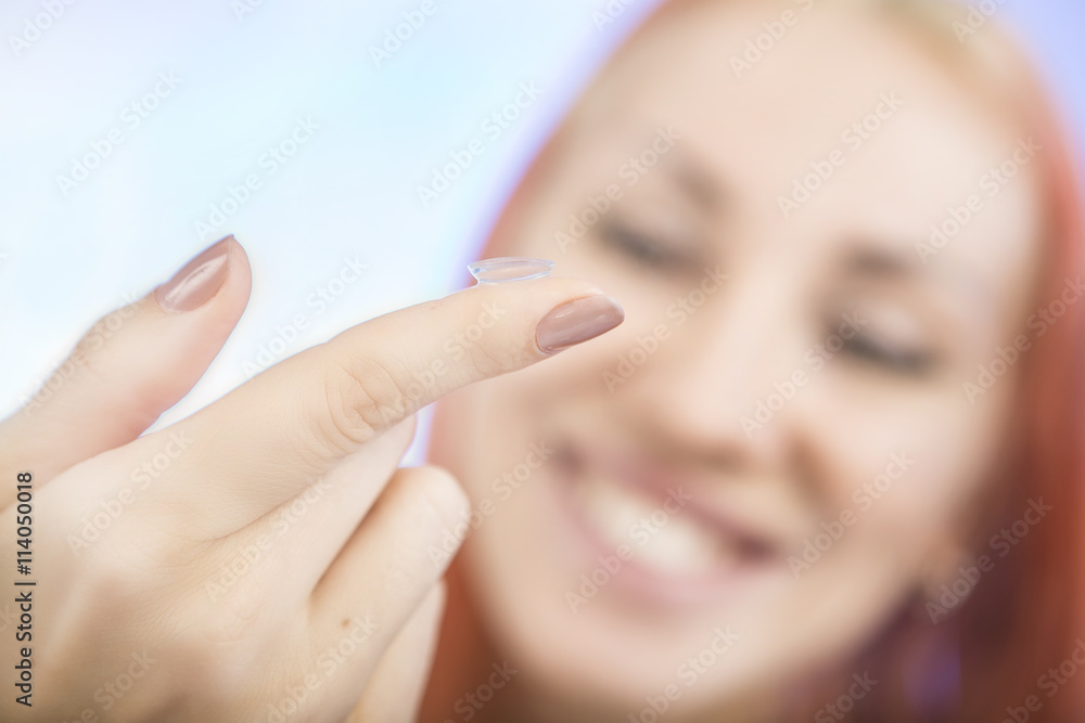 Contact lens: Young woman holding contact lens on finger in fron