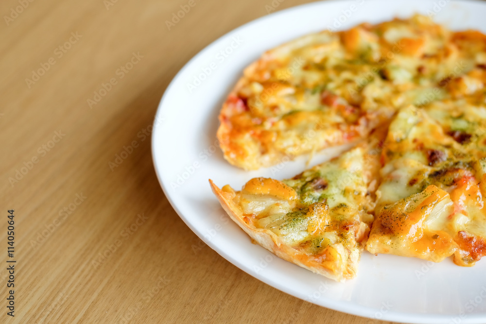 Hot pizza slice with melting cheese on wooden table Hot pizza slice with melting cheese on wooden table