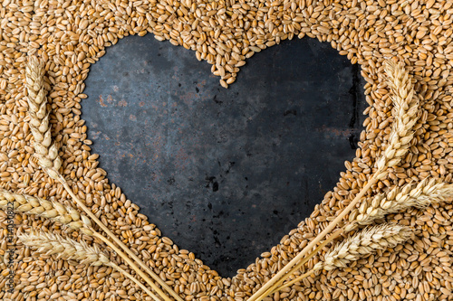 Grey metal heart from seeds of ripe golden wheat