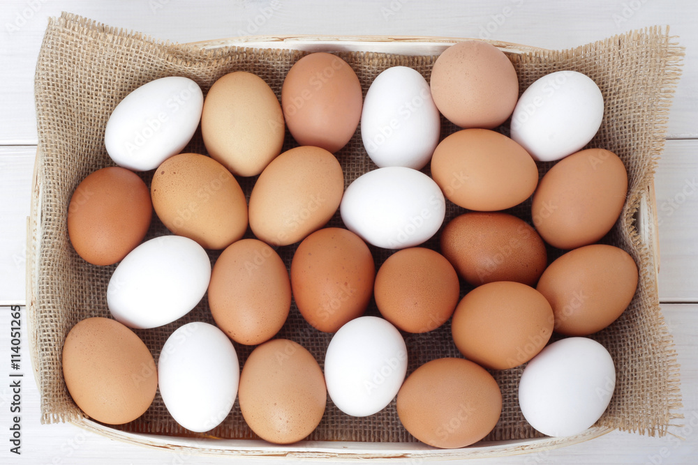 Brown and white chicken/hen eggs on wooden table Brown and white chicken/hen eggs on wooden table