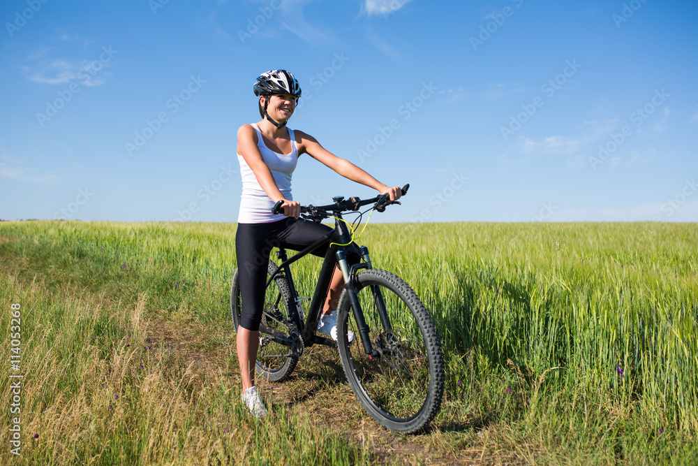 girl rides a bicycle in the countryside