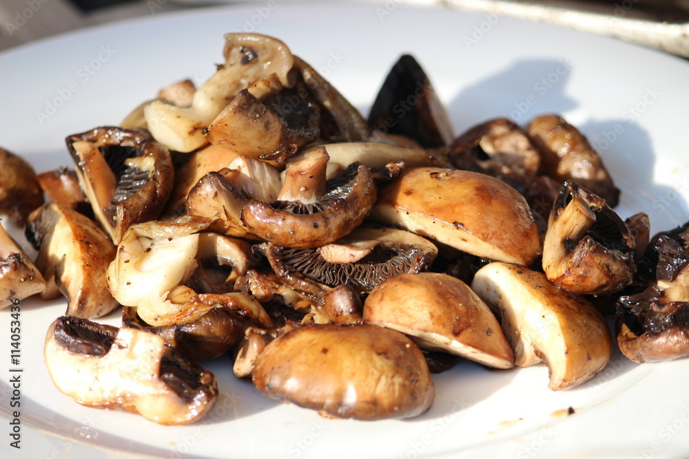 Grilled mushrooms on a white procelain plate Grilled mushrooms on a white procelain plate