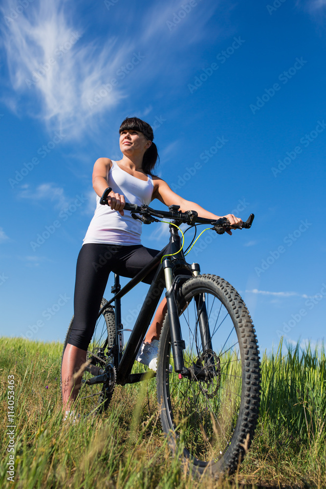 Mountain biking happy sportive girl relax in meadows sunny countryside