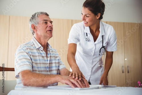 Nurse helping senior man with braille