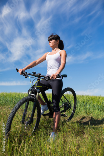 Mountain biking happy sportive girl relax in meadows sunny countryside