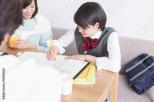 娘の勉強を見る両親