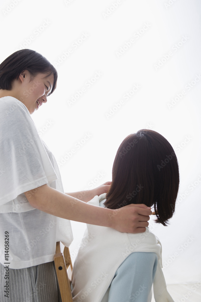 母親の肩をたたく娘 母親の肩をたたく娘