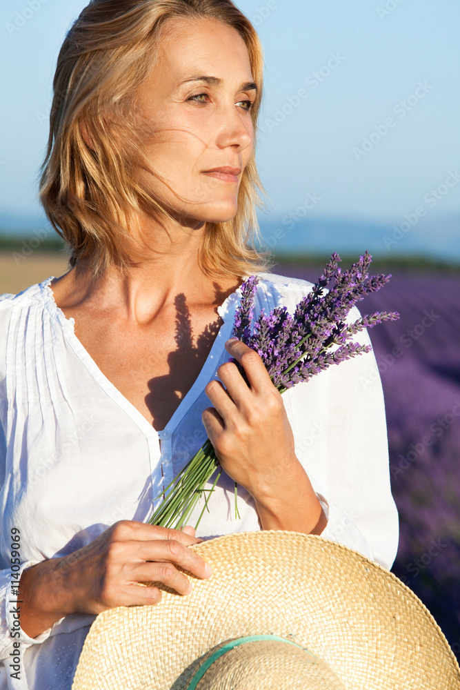 Naklejka premium femme avec un bouquet de lavande dans les champs