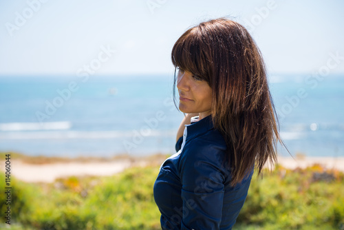 Beautiful woman posing in a park in from the beach © luismolinero