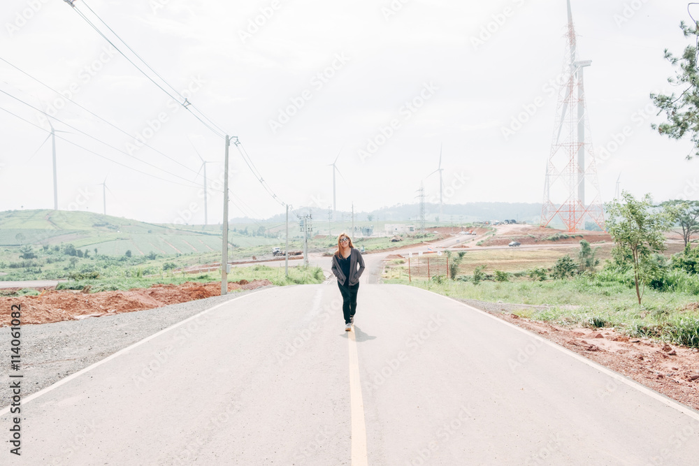 Asian girl walking on country road.