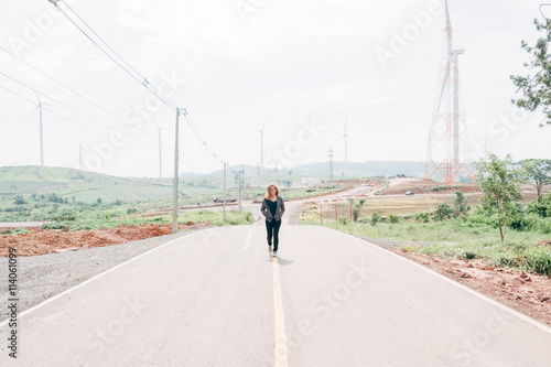 Asian girl walking on country road.