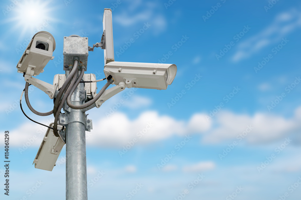 Group of security cameras (CCTV) or surveillance camera on pole isolated on blue sky background. Group of security cameras (CCTV) or surveillance camera on pole isolated on blue sky background.