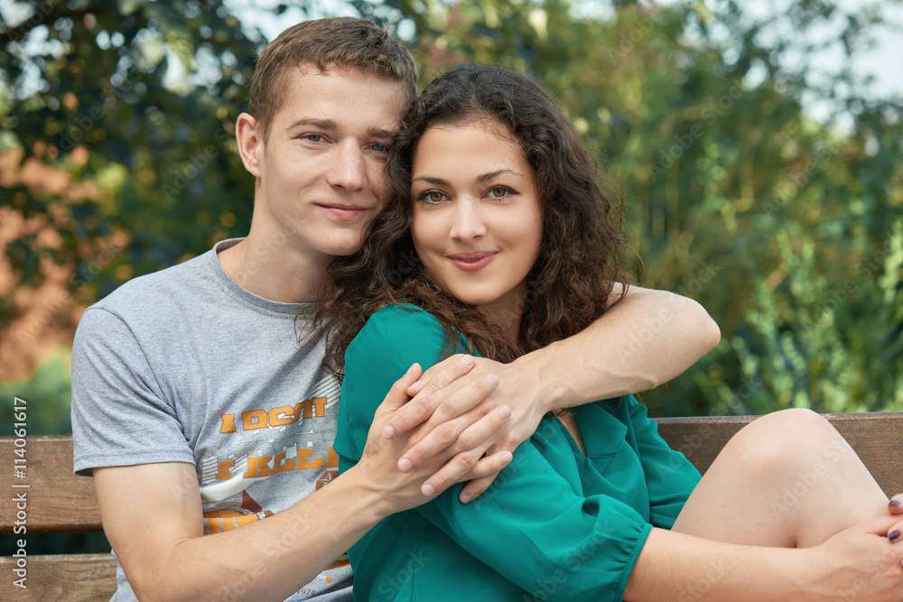Romantic couple posing in city park, summer season, lovers boy and girl Romantic couple posing in city park, summer season, lovers boy and girl