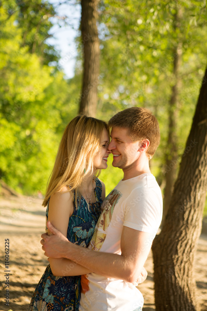 the young loving couple embraces outdoors in summer day
the young loving couple embraces outdoors in summer day