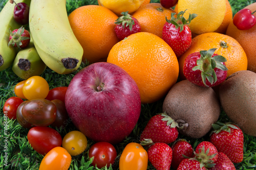 Assortment of exotic fruits on wooden table on green background Assortment of exotic fruits on wooden table on green background