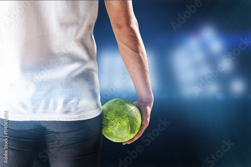 Composite image of mid section of athlete man holding ball 