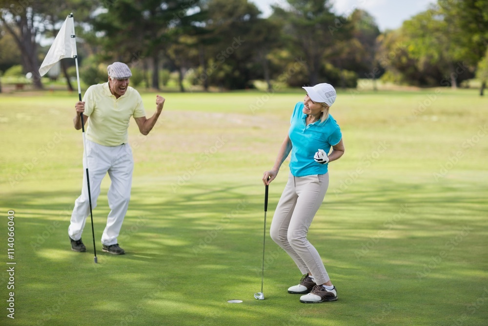 Mature golfer couple celebrating success 