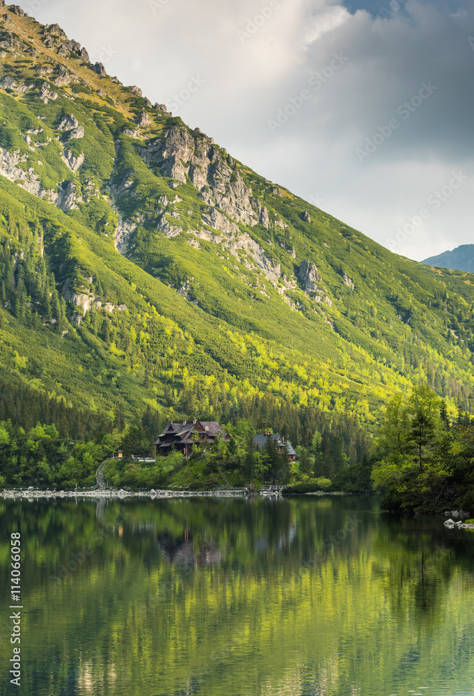Traditional wooden house and mountain reflection in lake