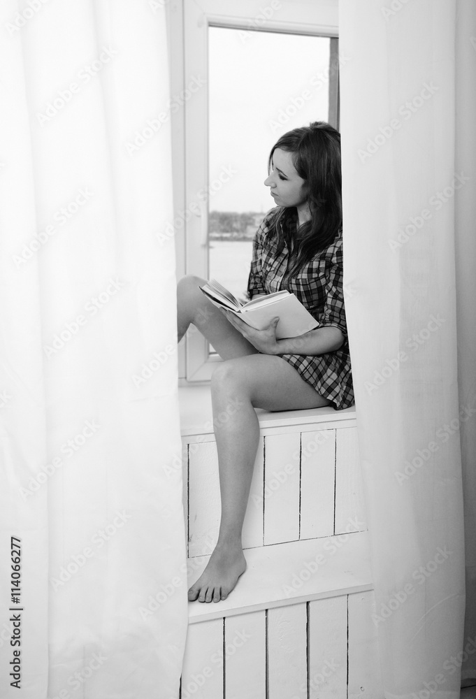 woman with a book looking through window
woman with a book looking through window