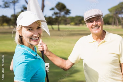 Cheerful golfer couple holding white flag
