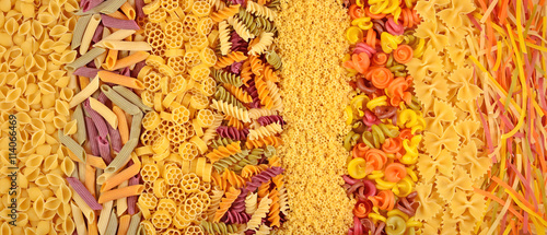 Assortment of colored uncooked Italian pasta as background