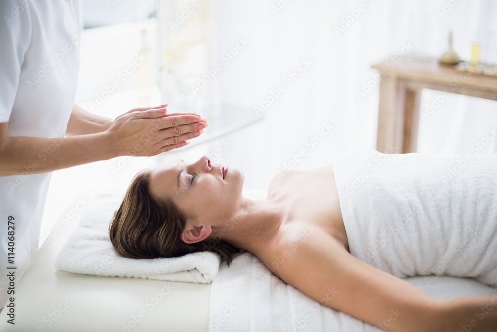 Midsection of therapist performing reiki on woman Midsection of therapist performing reiki on woman