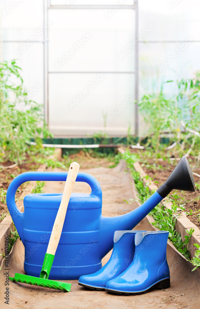 Colorful garden tools. watering can, rubber boots and rake. Colorful garden tools. watering can, rubber boots and rake.