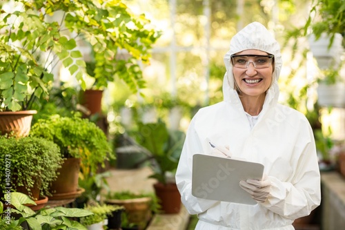 Wallpaper Mural Female scientist smiling while writing on clipboard Torontodigital.ca