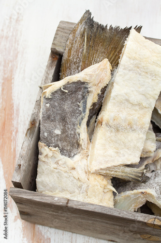 salted cod fish in wooden box on white background