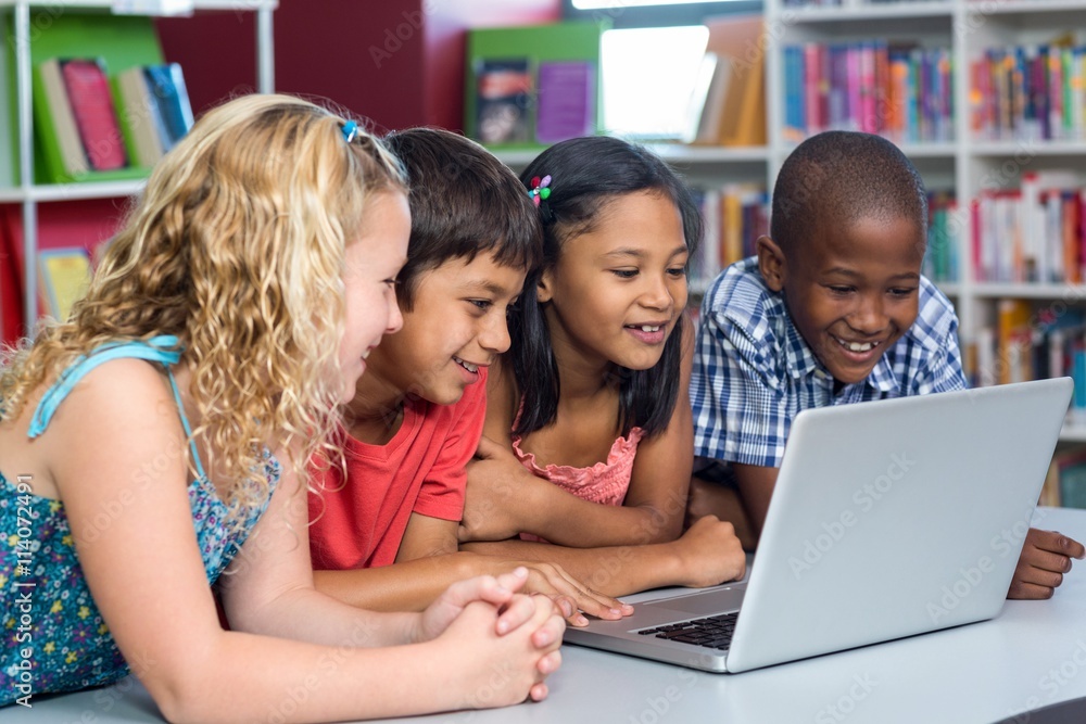 Happy multi ethnic classmates looking at laptop Happy multi ethnic classmates looking at laptop