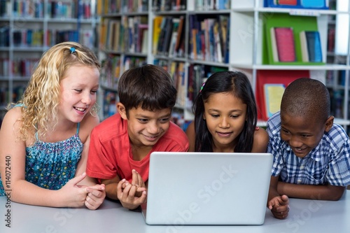 Cute classmates looking at laptop