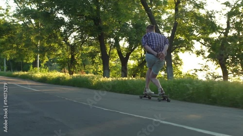 Wallpaper Mural handsome male riding longboard in park on sunny day slow motion Torontodigital.ca
