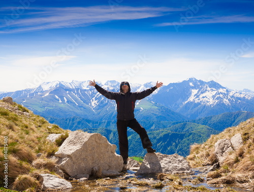 A man in mountain day summer. Rocky route. Blue sky.