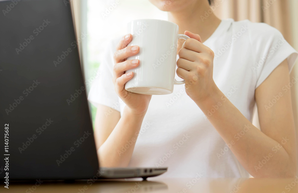 Young businesswoman drinking coffee and using laptop Young businesswoman drinking coffee and using laptop