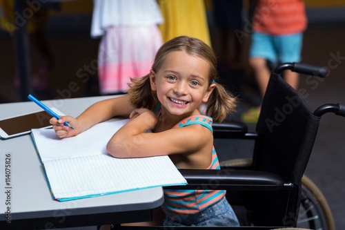 Quadro su tela Little girl in wheelchair in classroom