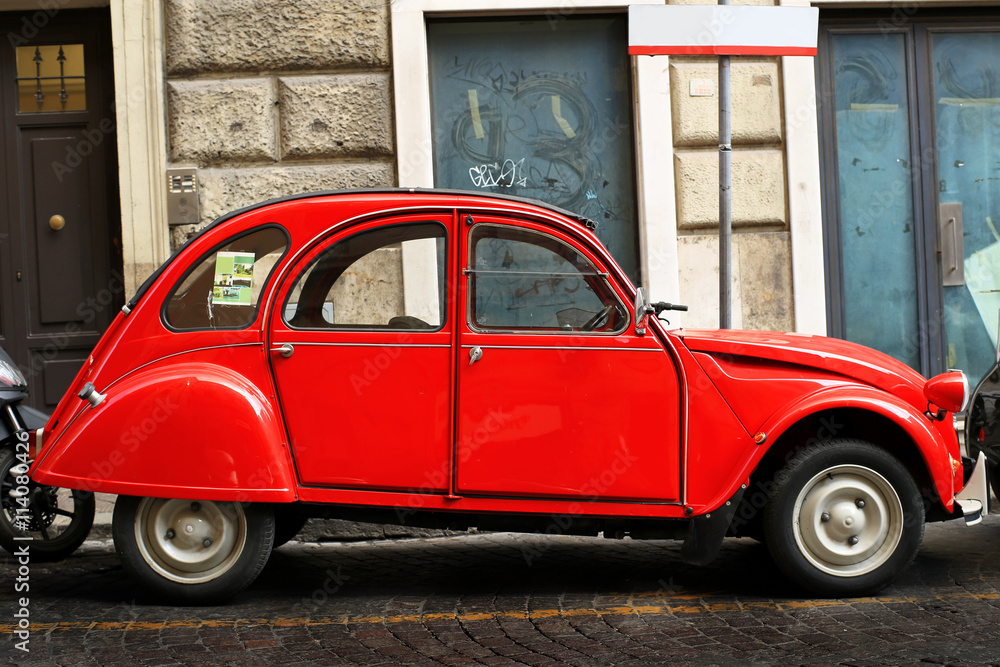 Red retro car on the street in Rome