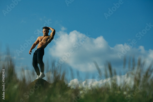 Sexy muscular man on sky background © Volodymyr