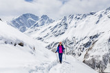 Hiker happy woman trekking on the snow in a snowy Caucasus mountains at spring