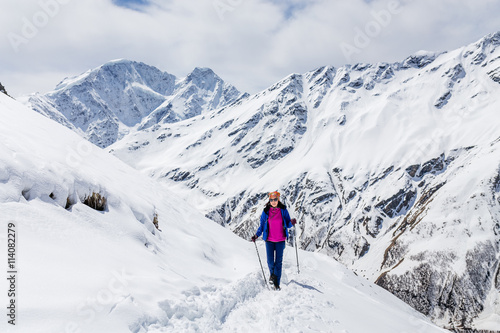 Hiker happy woman trekking on the snow in a snowy Caucasus mountains at spring