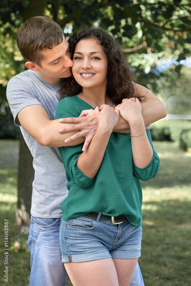 Romantic couple posing in city park, summer season, lovers boy and girl Romantic couple posing in city park, summer season, lovers boy and girl
