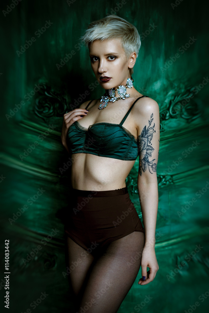 Fototapeta premium Studio portrait of beautiful fashionable woman with perfect sexy lingerie. Stylish girl, bright makeup, shorts, black tank top. 