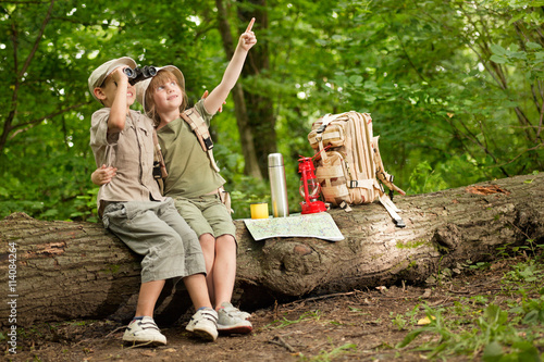 Canvas Print boy and a girl looking at birds through binoculars, camping in t