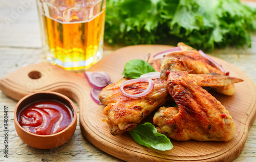 Delicious fried chicken wings with spices, red onion and ketchup