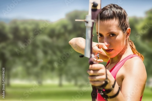 Fotografia Composite image of portrait of sportswoman practising archery